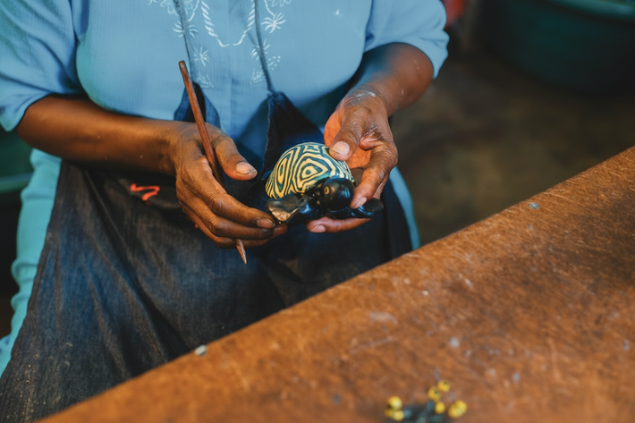 artesana africana con vela de tortuga
